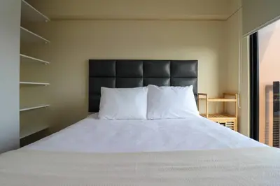 a bed with a black headboard and white pillows at Stunning 2BR with Balcony & City Views in Lima