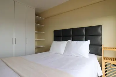 a bedroom with a large white bed with a black headboard at Stunning 2BR with Balcony & City Views in Lima