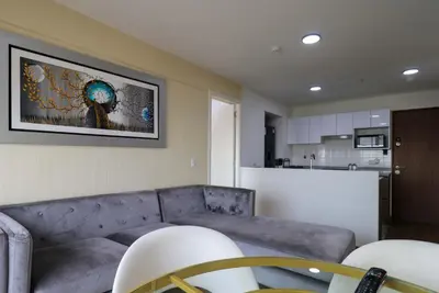 a living room with a couch and a kitchen at Stunning 2BR with Balcony & City Views in Lima