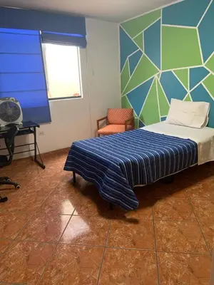 a bedroom with a bed with a blue and green wall at Apartamento cerca a lugares turísticos en Ica para 5 personas in Ica