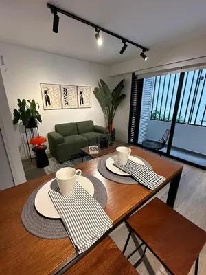 a living room with a table and a green couch at 1BDR Modern apartment in Barranco in Lima