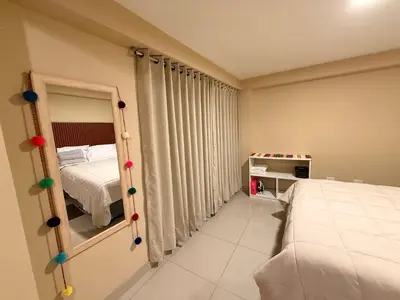 a small bedroom with a bed and a mirror at Tres Cruces Private Rooms in Cusco
