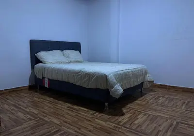 a bed in a room with a blue wall at Rustic Getaway in San Bartolo in San Bartolo