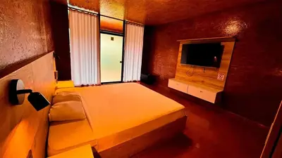 a bedroom with a bed and a window and a television at Club InkaVida - Pachacamac in Pachacamac