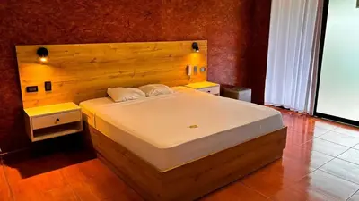 a bedroom with a large bed with a wooden headboard at Club InkaVida - Pachacamac in Pachacamac