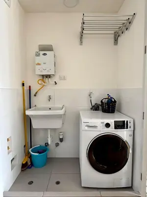 a laundry room with a washing machine and a sink at Departamento Graña in Lima