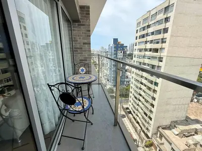 a balcony with a table and chairs and a view at Departamento Graña in Lima