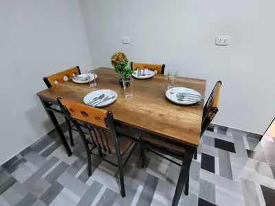 a wooden table with chairs and plates and flowers on it at La Casa de ANNI in Oxapampa
