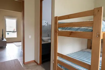 a room with two bunk beds and a bathroom at Casa Cieneguilla in Cieneguilla