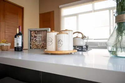 a kitchen counter with two coffee mugs and wine bottles at Casa Cieneguilla in Cieneguilla