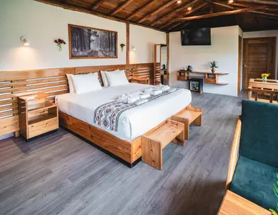 a bedroom with a large bed and a couch at Tara Vegan Lodge - Sacred Valley in Urubamba
