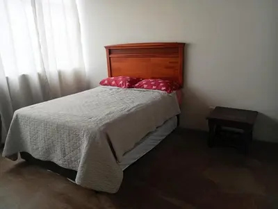 a bedroom with a bed with red pillows on it at Apartment facing Mirador Analí in Punta Hermosa