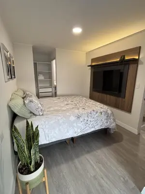 a bedroom with a bed and a flat screen tv at 2BR Apartment with Pool near Larcomar in Lima