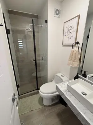 a bathroom with a shower and a toilet and a sink at 2BR Apartment with Pool near Larcomar in Lima
