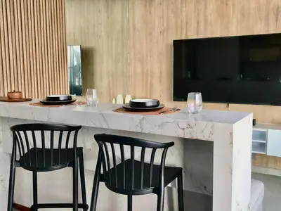 a bar with two chairs and a table with a television at 2BR Apartment with Pool near Larcomar in Lima