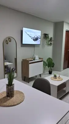 a living room with a white table and a tv on the wall at Sweet Home in Lima