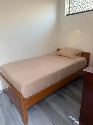 a bed in a room with a wooden bed frame at Habitacion San Borja in Lima