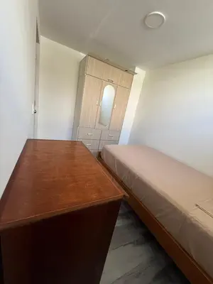 a small bedroom with a bed and a wooden desk at Habitacion San Borja in Lima
