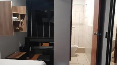 a bedroom with a piano and a bathroom with a toilet at HotelesR20 in Lima