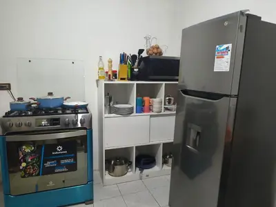 a kitchen with a stove and a refrigerator at Cusco - Flor de Loto in Cusco