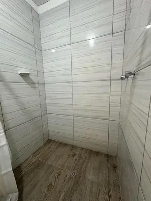 a bathroom with a shower with a wooden floor at Cusco - Flor de Loto in Cusco