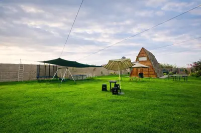 a yard with a tent and a table in the grass at Cabaña las Palmeras de Chincha