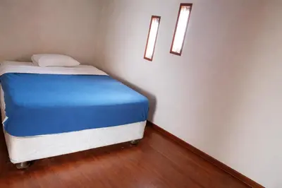 a small bed in a room with two lights at Casa Matta in Sunampe
