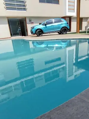 a blue car parked next to a swimming pool at Casa Matta in Sunampe