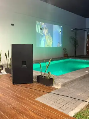 a man is on a screen next to a swimming pool at Casa LeBlanc in Ica