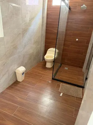 a bathroom with a toilet and a glass shower at Casa LeBlanc in Ica
