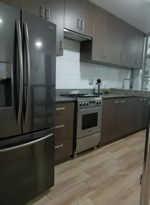 a kitchen with stainless steel appliances and wooden cabinets at Costanera Tourist Free Parking 3B 708 in Lima