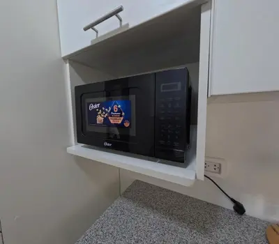 a microwave oven in a shelf in a kitchen at Apartamento nuevo en San Bartolo con vista al mar in San Bartolo