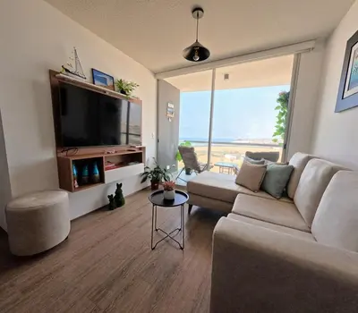 a living room with a couch and a flat screen tv at Apartamento nuevo en San Bartolo con vista al mar in San Bartolo