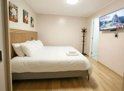 a bedroom with a bed and a flat screen tv at E SuiteCost FreeParking San Miguel 1B 708 in Lima