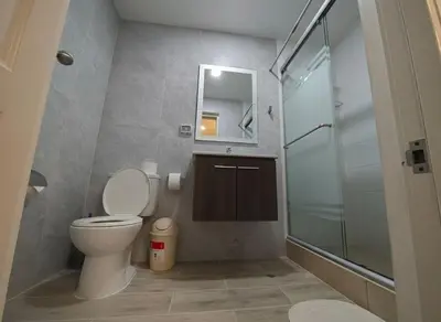 a bathroom with a toilet and a glass shower at E SuiteCost FreeParking San Miguel 1B 708 in Lima
