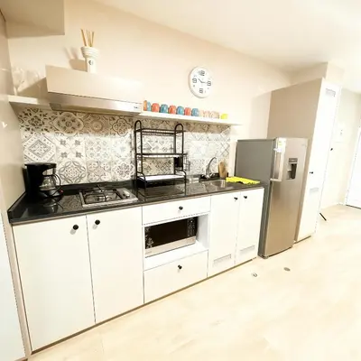 a kitchen with white cabinets and a stainless steel refrigerator at E Free Parking Patio Privado Barranco 1B 109 in Lima