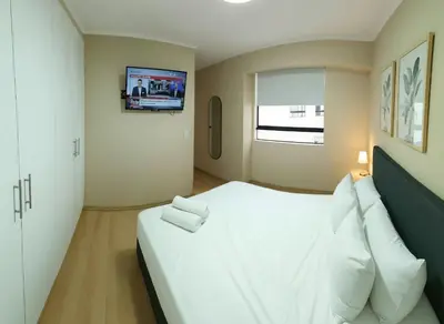 a bedroom with a large white bed and a television at E Free Parking Wifi Pro Laundry 1B 204 in Lima