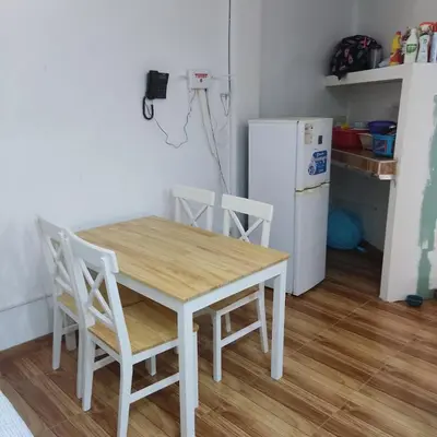 a kitchen with a table and chairs and a refrigerator at La Palmera Apartment in San Bartolo