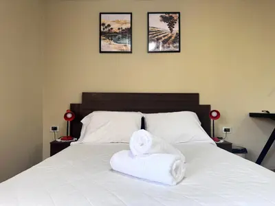 a bedroom with a bed with two towels on it at Peruvian Apartments La Angostura in Ica