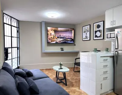 a living room with a couch and a tv on the wall at Peruvian Apartments La Angostura in Ica