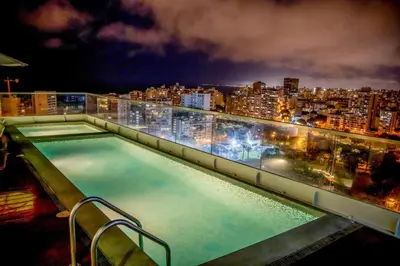a swimming pool on top of a building at night at Peruvian Apartments Barranco 1404 in Lima