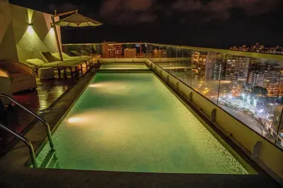 a swimming pool on top of a building at night at Peruvian Apartments Barranco 1404 in Lima