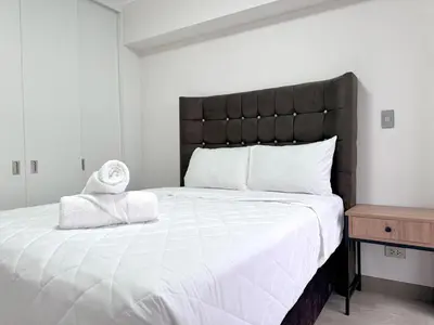 a bedroom with a large bed with a black headboard at Peruvian Apartments Barranco 1710 in Lima