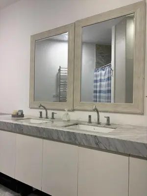 a bathroom with two sinks and two mirrors at Huaca Pucllana Design Apartment between Miraflores and San Isidro in Lima