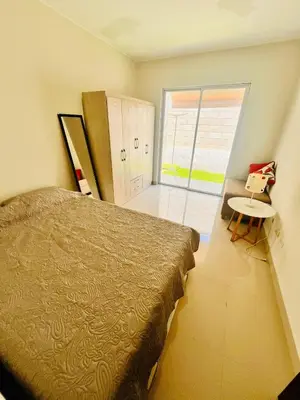 a bedroom with a bed and a table and a window at Casa privada y acogedora en Ica con Parking in Ica