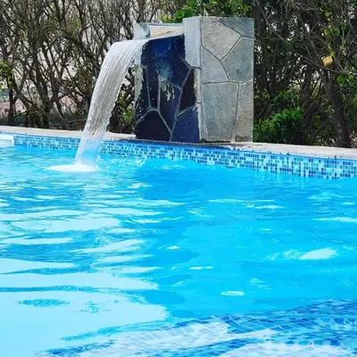 a pool with a water fountain in a swimming pool at Casa de campo Cieneguilla Vista Bonita in Cieneguilla