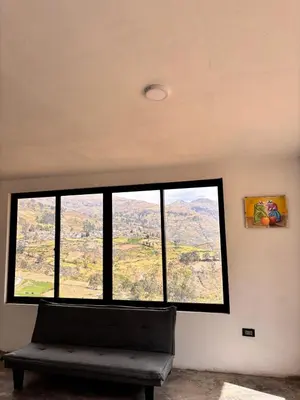 a large window in a room with a bench at House with a panoramic view of the city and mountains in San Miguel