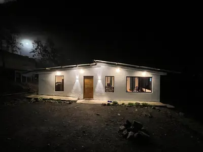 a small white house at night with lights at House with a panoramic view of the city and mountains in San Miguel
