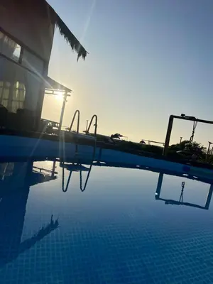 a swimming pool with the sun reflecting in the water at Refugio 55 Casa de Playa en Chincha, Frente al mar in Chincha Baja