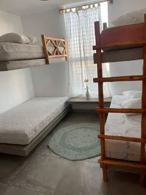 a bedroom with two bunk beds and a rug at Refugio 55 Casa de Playa en Chincha, Frente al mar in Chincha Baja